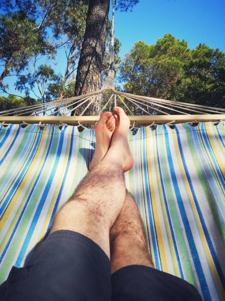 man legs resting on a hammock on vacation