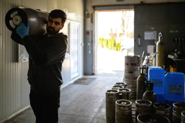 istock Brewer moving kegs in brewery 1162294185