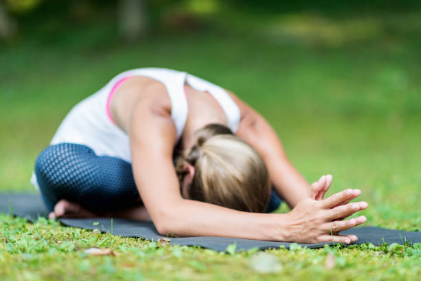 istock Woman Practicing Yoga In Park 1162297437