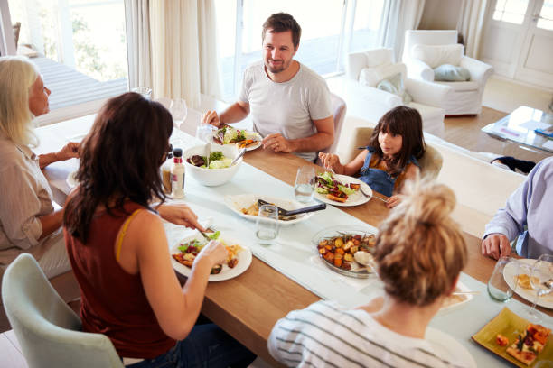 istock Three generation white family sitting at the dinner table for a family meal, elevated view 1162300145