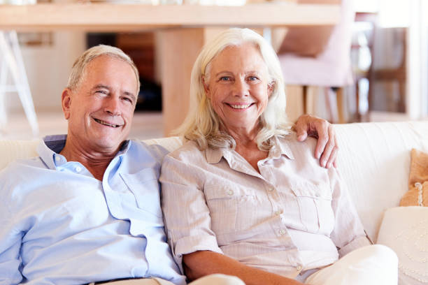 istock Senior white couple relaxing at home, smiling to camera, front view, close up 1162300253