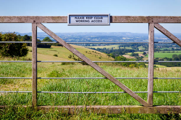 istock Farm gate, with sign, with the countryside behind 1162301167