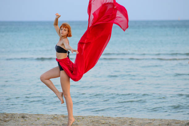 istock Woman in red dress run on beach 1162301435
