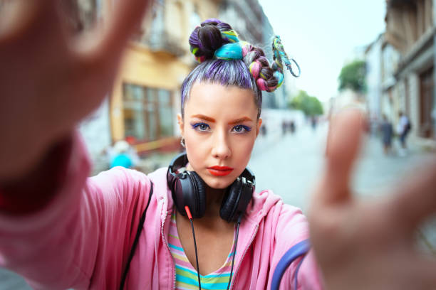 cool funky young girl with headphones and crazy hair enjoy power of music taking selfie on street - hipster woman with trendy avant-garde look feeling awesome - music fan concept with carefree teen having fun - city life audio imagens e fotografias de stock