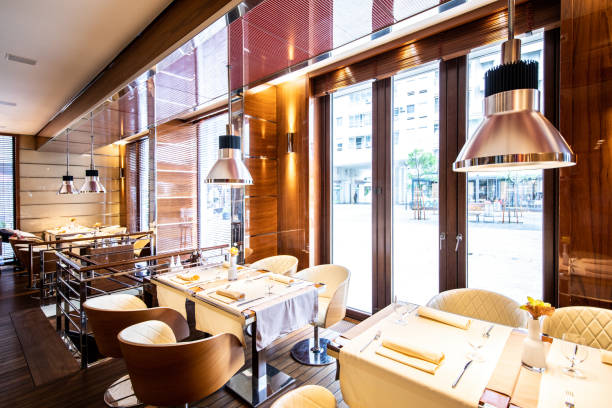 istock Rows of tables and seats set next to a luxurious restaurant's windows 1162302116