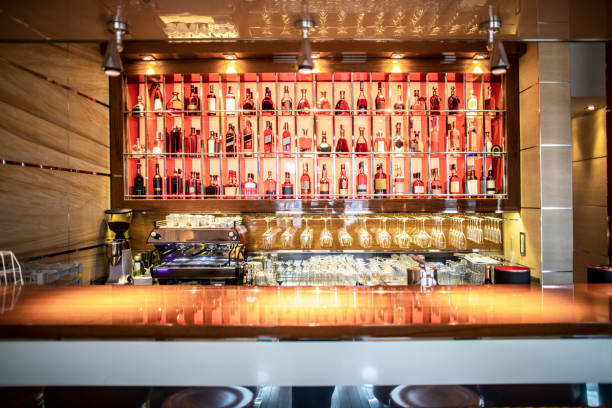 A bar with drinks display in a prestigious restaurant An alcoholic beverages display shelf at a bar of a high class restaurant. whisky cellar stock pictures, royalty-free photos & images