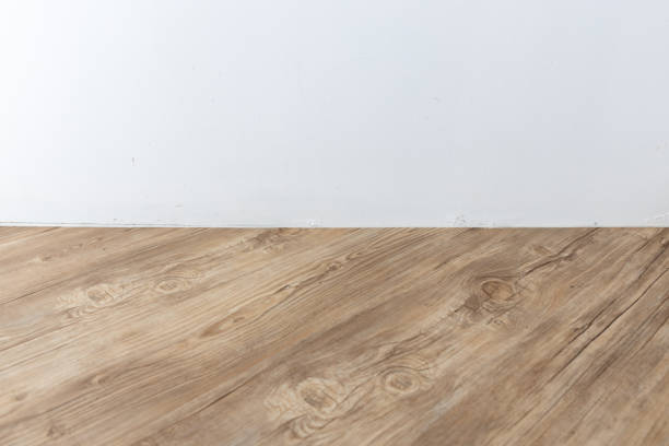 istock perspective view of empty interior room with white cement wall and brown wooden herringbone floor. 1162303095