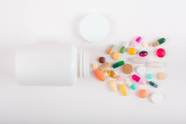 istock Assorted pharmaceutical medicine pills, tablets and capsules and bottle on white background. Copy space for text 1162303127