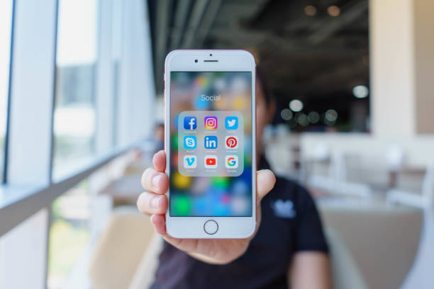 frau hält apple iphone 6s rose gold mit symbolen der sozialen medien auf dem bildschirm. social media sind das beliebteste tool.  smartphone-lebensstil. starten der social-media-app. - iphone stock-fotos und bilder