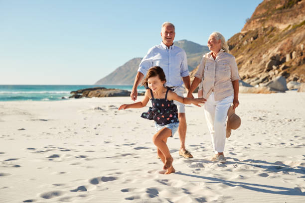 istock Senior white couple and their granddaughter walking on a sunny beach, close up 1162303473