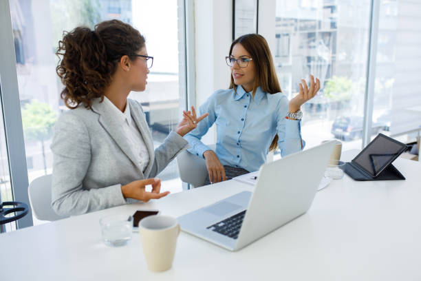 istock Businesswomen with laptop cooperating at work 1162306311