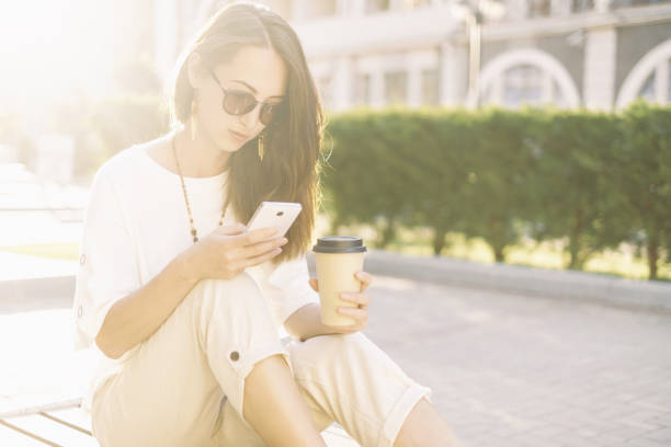 istock Beautiful girl using phone while sitting with cup of coffee. 1162306394
