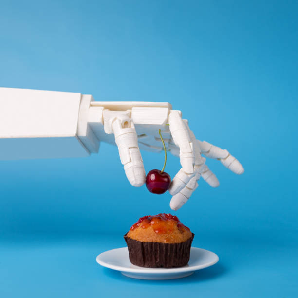 Robot hand decorating sweet cupcake with fresh cherry Chef robotic assistant in kitchen technology. Robot hand decorating sweet cupcake with fresh cherry, blue background telegram machine photos stock pictures, royalty-free photos & images