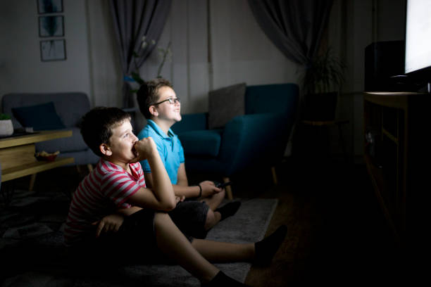 Boys watching a movie at home at night