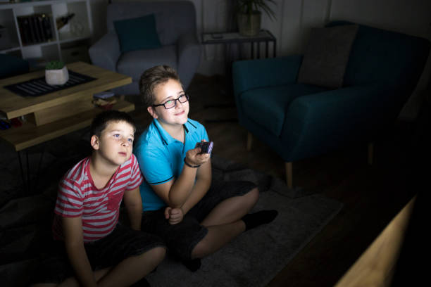 istock Boys watching a movie at home at night 1162308718