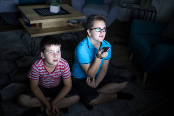 istock Boys watching a movie at home at night 1162308998