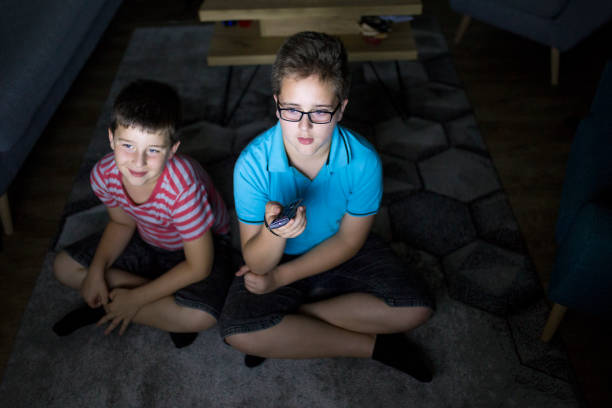 istock Boys watching a movie at home at night 1162309360