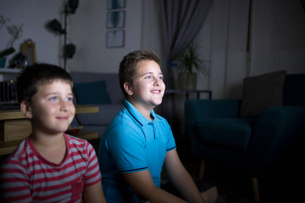 istock Boys watching a movie at home at night 1162309755