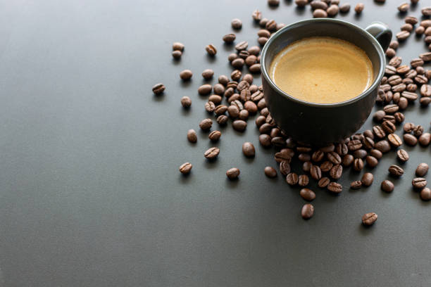 istock hot espresso and coffee bean on black table with soft-focus and over light in the background. top view 1162312078