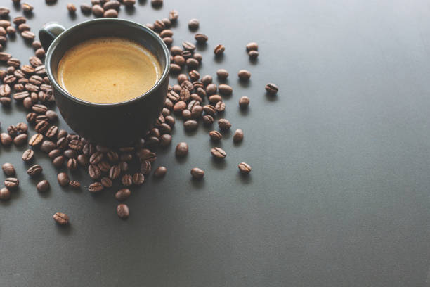 istock hot espresso and coffee bean on black table with soft-focus and over light in the background. top view and vintage color tone 1162312087