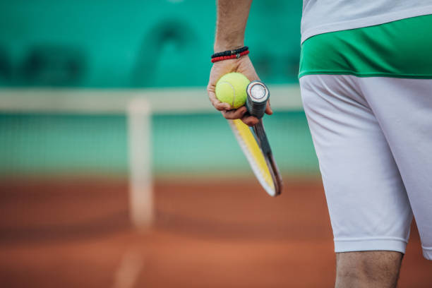 istock Tennis player holding a ball and racket 1162312112