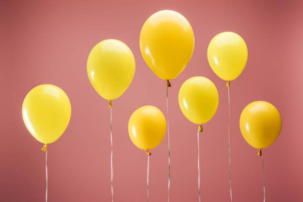 istock yellow balloons on pink background, party decoration 1162313666