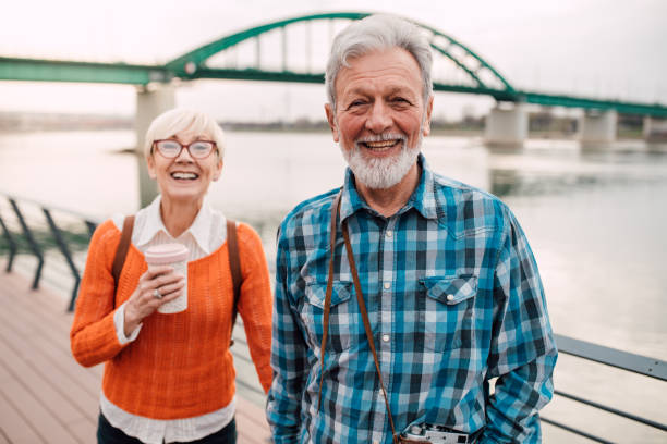 istock Mature couple at waterfront strolling and laughing 1162316911