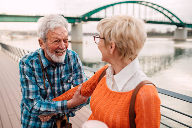istock Mature cheerful couple at waterfront talking and laughing 1162316917