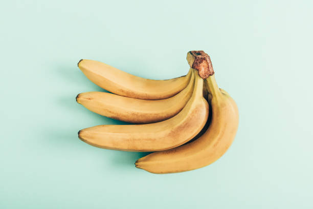 istock Bunch of ripe bright bananas on turquoise background 1162316977