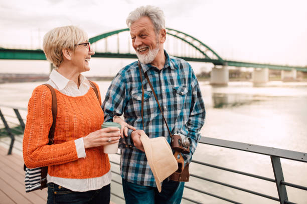 istock Senior couple at waterfront walking and smiling 1162318223