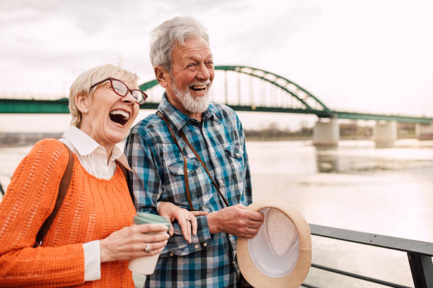 istock Elderly couple at waterfront walking and laughing 1162318439