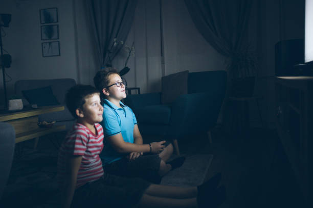 istock Boys watching a movie at home at night 1162318785