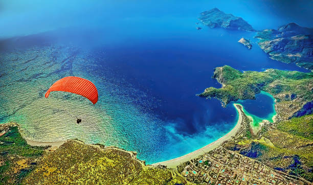 parapente volando en fethiye sobre la laguna azul en oludeniz, turquía - caída libre paracaidismo fotografías e imágenes de stock