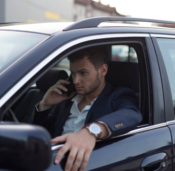 istock Young handsome businessman talking on mobile phone in the car 1162320580