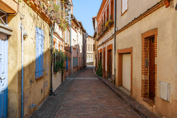 street in french ancient town toulouse. toulouse is the capital of haute garonne department and occitanie region, france, south europe. famous tourist destionation. - people cemetery church urban scene imagens e fotografias de stock