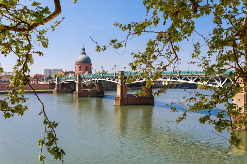 French ancient town Toulouse and Garonne river panoramic view. Toulouse is the capital of Haute Garonne department and Occitanie region, France, South Europe. Famous city and tourist destionation.
