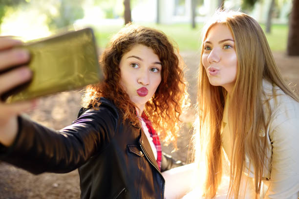 istock Two young woman making selfie in sunny park 1162323206