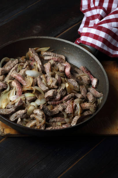 istock Fried beef and onions in a pan - preparation for beef stroganoff 1162328094