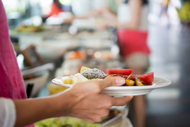 istock Woman holding plate with fruit at the hotel buffet 1162332453