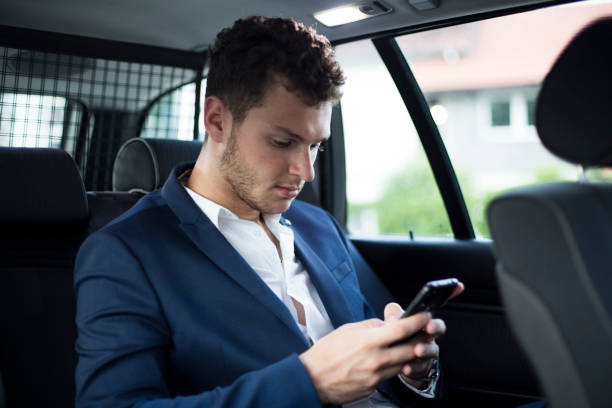 istock Young handsome businessman talking on mobile phone in the car 1162332613