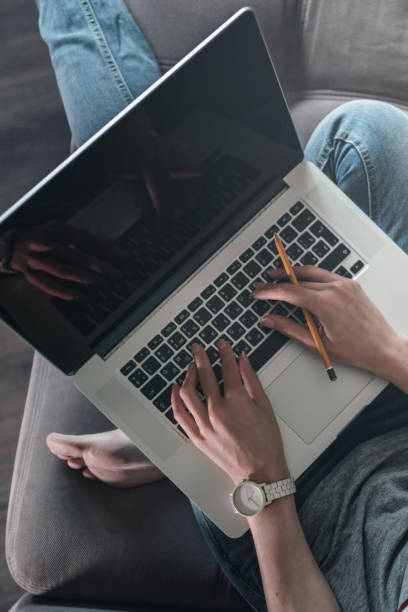 istock Woman using laptop with blank black screen. 1162333440