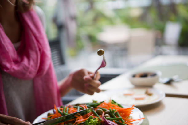 istock Woman eating salad in a cafe 1162334654