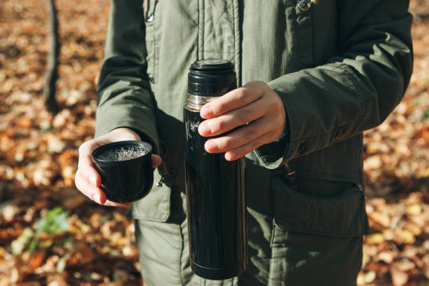 istock Person with a thermos in his hands. 1162335605