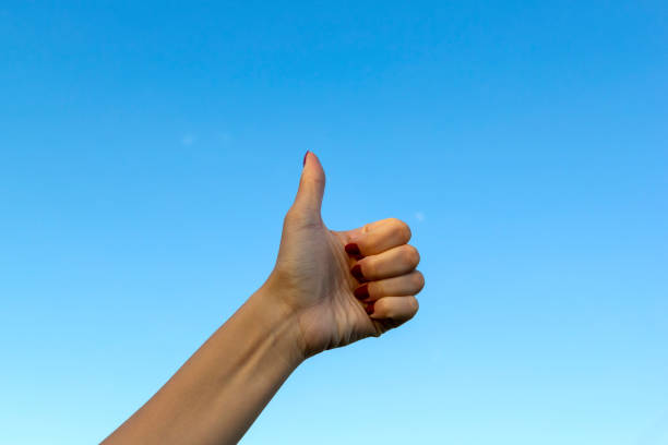istock Hand gesturing thumbs up showing good or ok on blue sky background. 1162336404