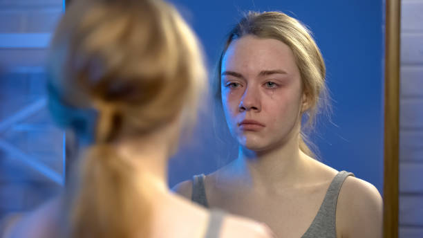 istock Young female suffering depression, crying looking at mirror reflection, despair 1162337116