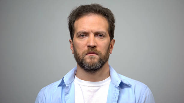 istock Sad young man on grey background, male loneliness, suffering breakup depression 1162337128