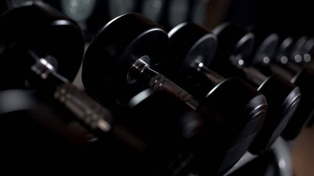 close up dos dumbbells, equipamento do treinamento da força na ginástica, acessórios dos esportes - weights men weight picking up - fotografias e filmes do acervo