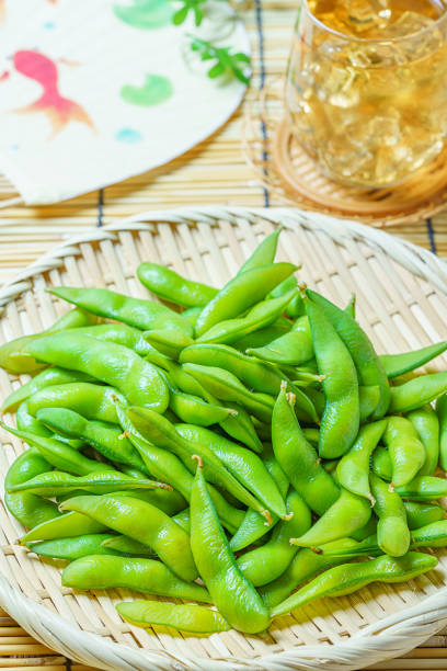 istock Boiled green soy beans and a cold japanese tea, (and japanese fan) 1162338156