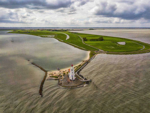 вид с воздуха на маяк в маркене, небольшом острове посреди маркермеера в нидерландах. - netherlands dyke polder aerial view стоковые фото и изображения