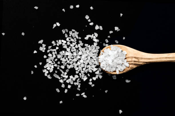 istock Wooden spoon with salt on black background - Image 1162341678